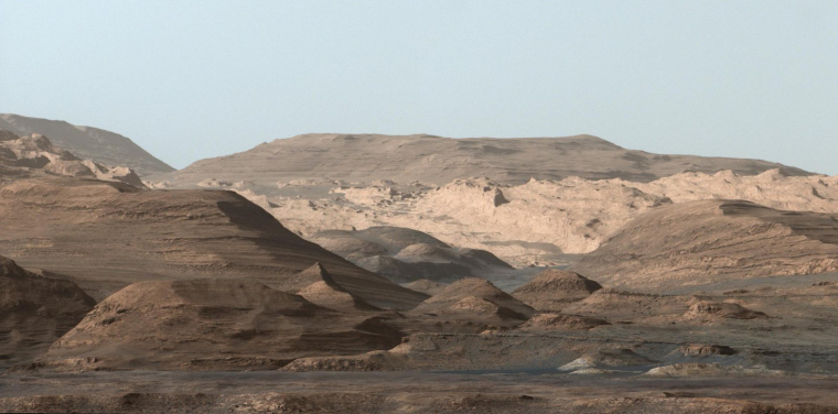 由好奇號火星車全景相機所拍攝的蓋爾撞擊坑中夏普山的層狀沉積岩。火星車從蓋爾隕石坑的底部向上行駛，正在穿過這些山丘，以探索該剖面較低處岩石（年齡較老）形成環境到較高處岩石（年齡較年輕）形成環境的演化。從好奇號任務開始至今，共穿越了垂直高度超過 400 米的岩石剖面。(相片來源: 美國太空總署好奇號火星車)